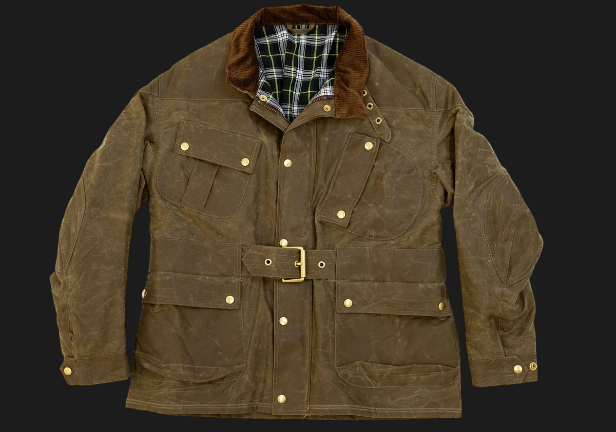 A brown waxed canvas utility jacket with a brown corduroy collar, gold-tone snap buttons, and a matching belt with a brass buckle, displayed against a solid black background.
