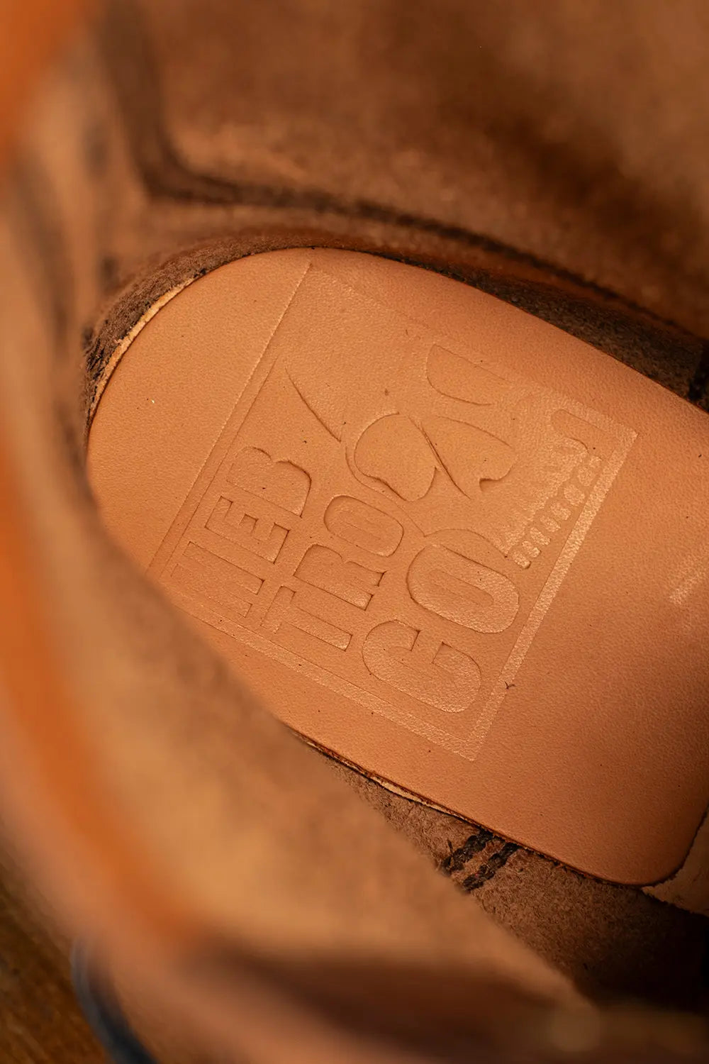 Close-up of the tan leather insole of a boot, embossed with the brand name 'LEB TROSO' and 'EST. 2003'.