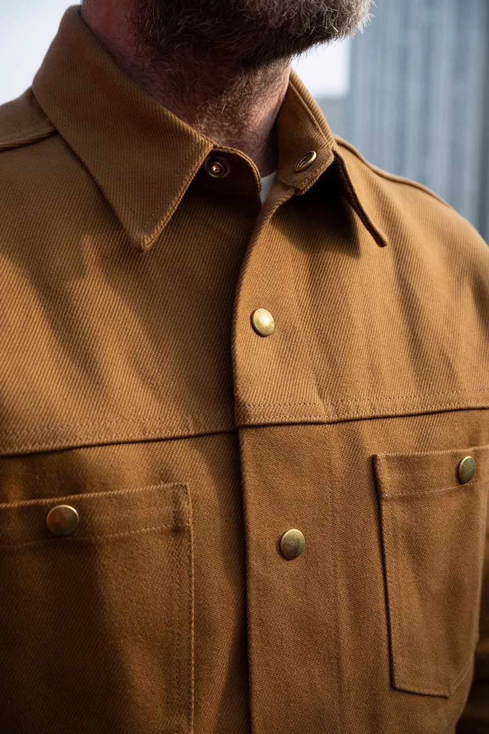 Close-up of Ed wearing a Jute Ironshirt with brass buttons and chest pockets.